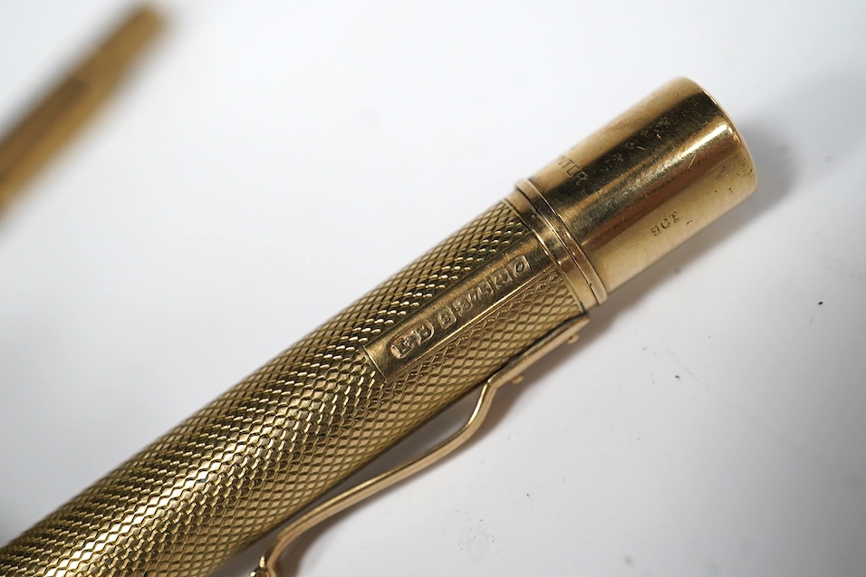 Two engine turned 9ct gold pencils, hallmarked for London, 1959 and London, 1969, both approx. 11.8cm. Condition - fair to good